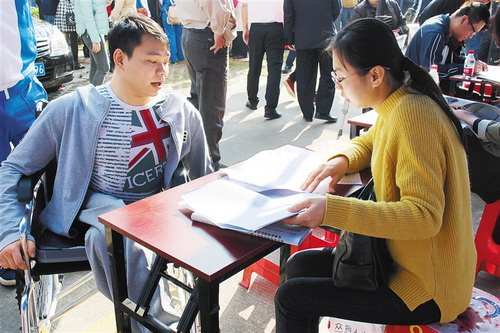 1月18日,省残疾人就业月专场招聘会现场,前来求职的残疾人与工作人员正在交流。